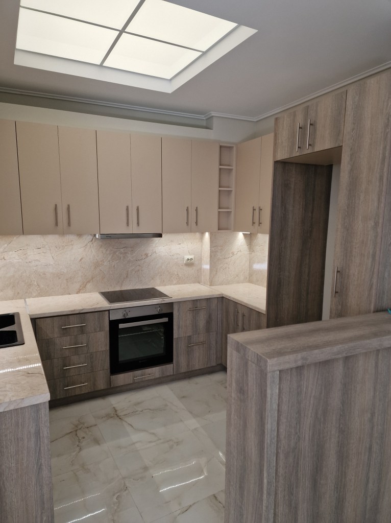 Σύνθεση κουζίνας σε ζεστές αποχρώσεις ξύλου με ανοιχτόχρωμες επενδύσεις πάγκου περιμετρικά και εργονομικό σχεδιασμό - Kappawood