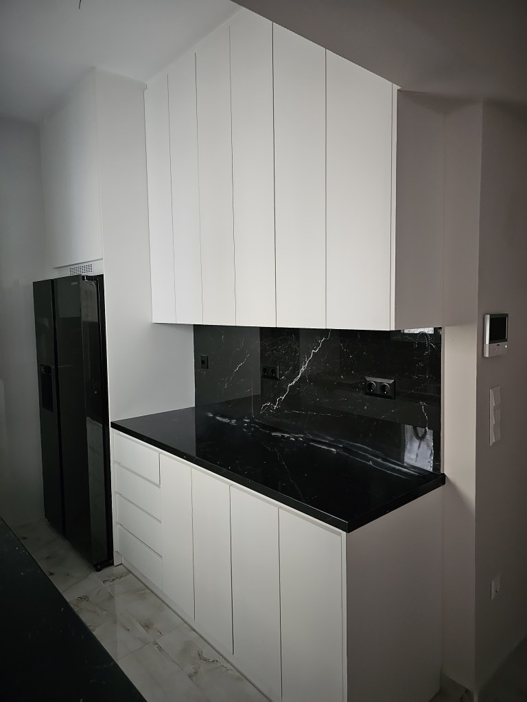 Μοντέρνα κουζίνα με λευκές ακρυλικές ματ επιφάνειες, πάγκο απομίμησης μαρμάρου και ψηλά ντουλάπια αποθήκευσης - Kappawood