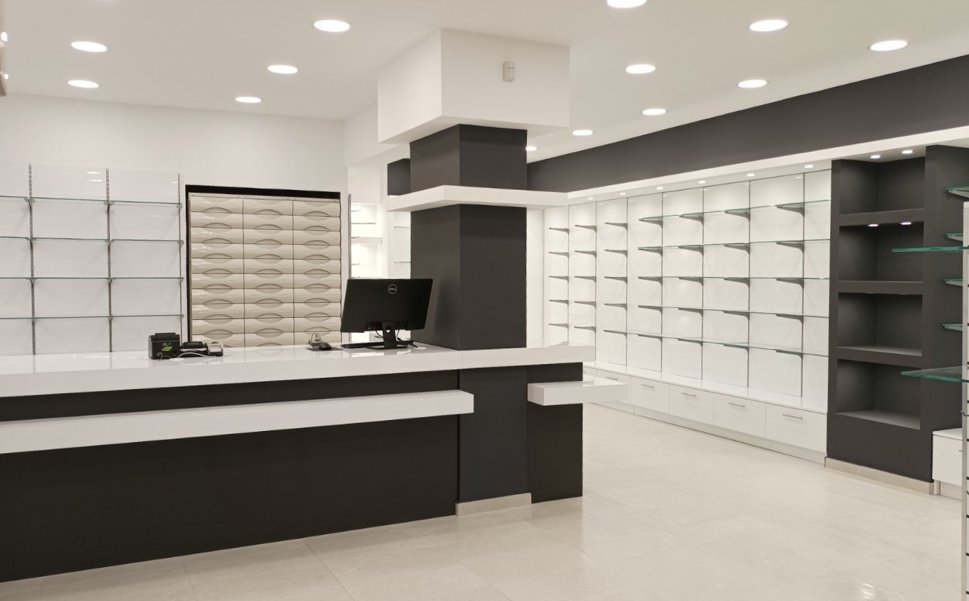 Ολοκληρωμένος εξοπλισμός μεγάλου φαρμακείου με λευκό γυαλιστερό ακρυλικό, ανθρακί λεπτομέρειες, κεντρικό πάγκο εργασίας και ενσωματωμένες συρταριέρες - Kappawood